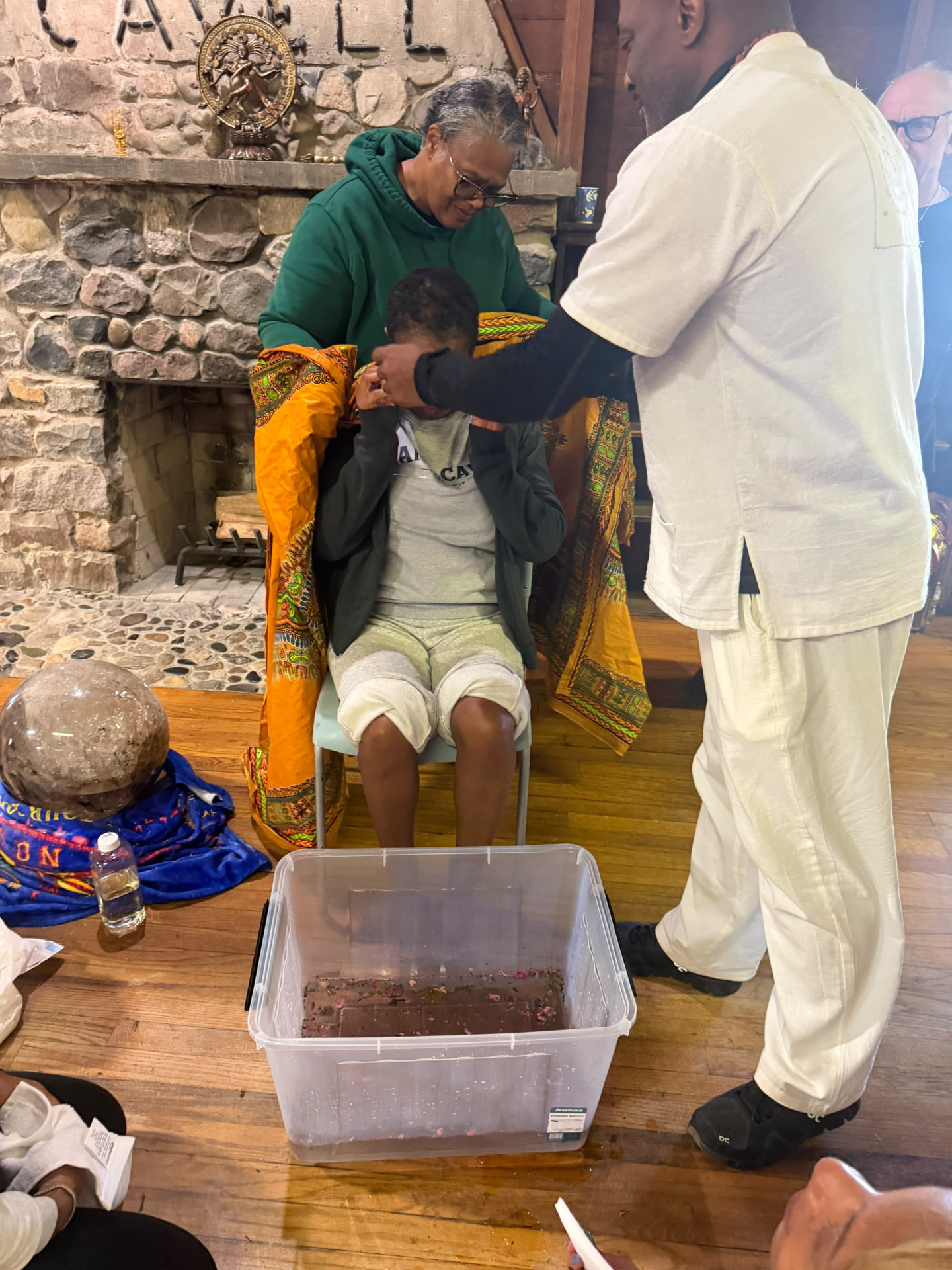 Facilitators tend to a seated participant during the ritual